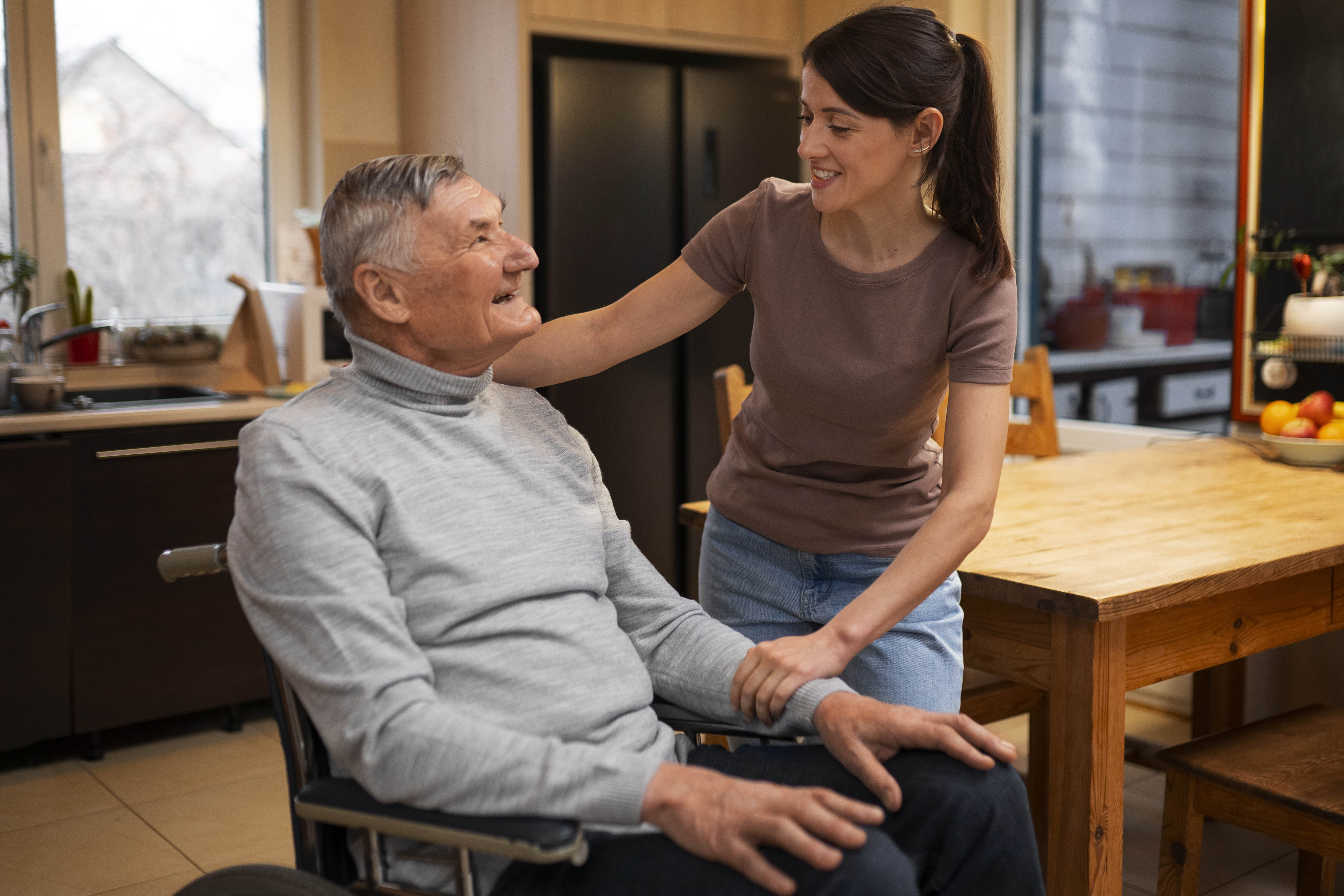 Female caretaker assisting an elderly person with daily activities.